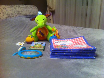 Игрушки дракоша, книги, расческа и погремушка